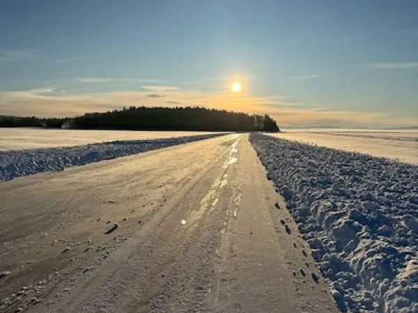 Plogad skridskobana på en sjö en solig vinterdag.