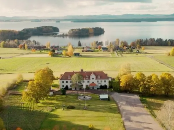 Hotel on fields with a lake in the background in autumn.