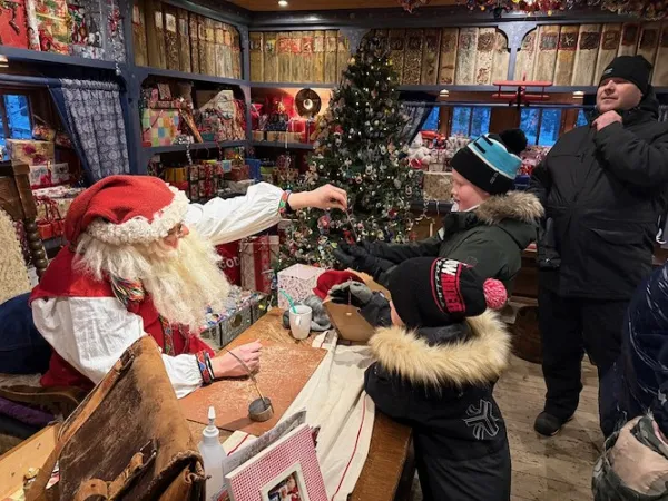 Children dressed for winter talking to Santa