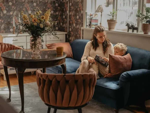 A woman with a child in the sofa.