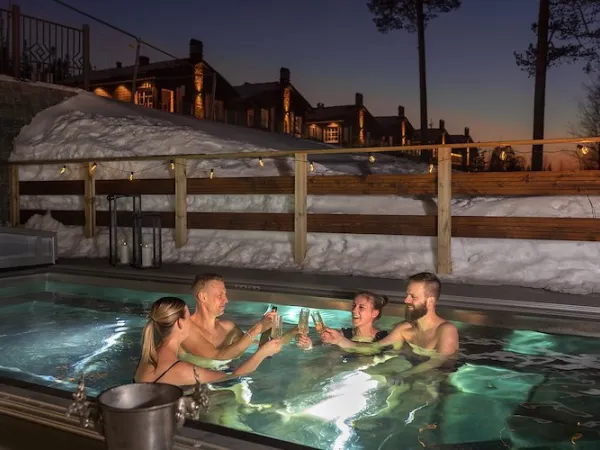 Två par skålar med varandra i varm pool med snödrivor runtomkring. 