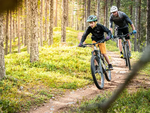 Pojke och man cyklar mountainbike.