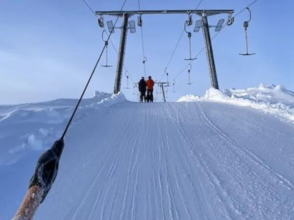 Två personer på väg upp i en skidlift.