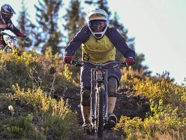 Downhill by bike descend paths on steep mountains.