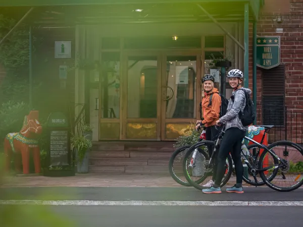 Två kvinnor går med sina MTB cyklar