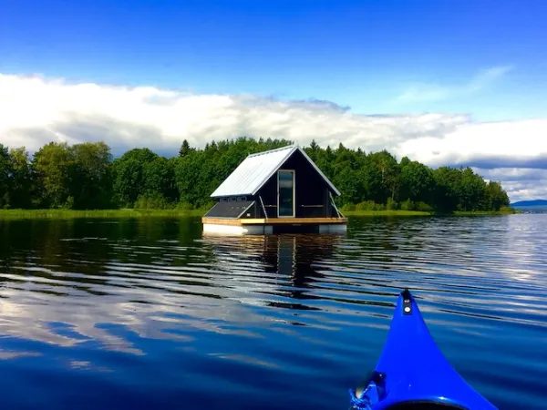 Stuga på en flotte i vattnet. 