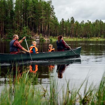 Familj och paddlar kanot.