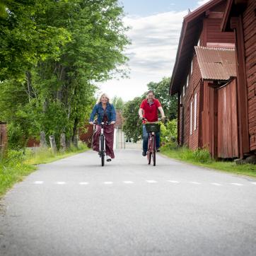 Cyklister på väg bland fina röda hus.