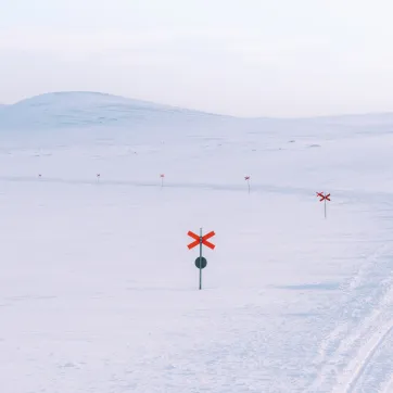 Vy över fjällen i Grövelsjön i snölandskap.