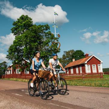 Couple cycling on a country road outside Rättvik.