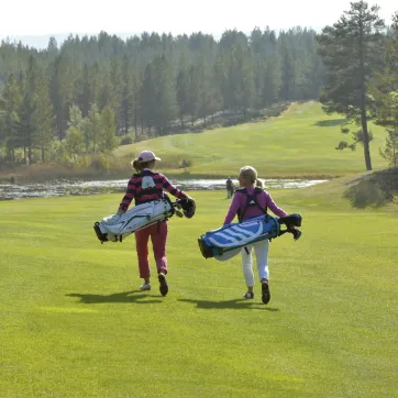 Två golfare går på golfbana.