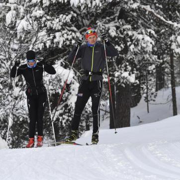 Two cross country skiers in a trail.