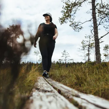 Kvinna som vandrar på spång i naturen.