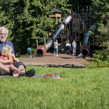 A grandpa and his grandchild at a playground.