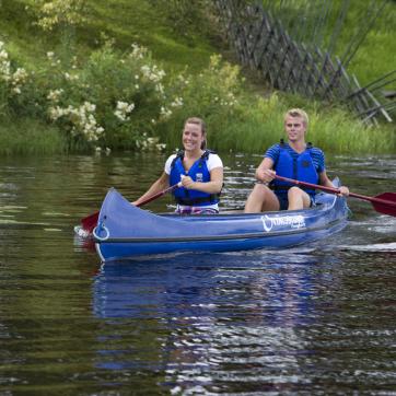 Två personer i en kanot på sjö.