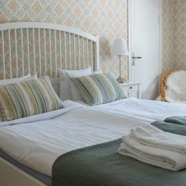En fint bäddad säng i ett hotellrum.