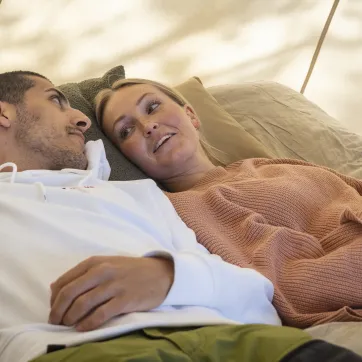 Par som ligger i en säng.