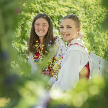 Two girls binding flowers during solstice midsummer.