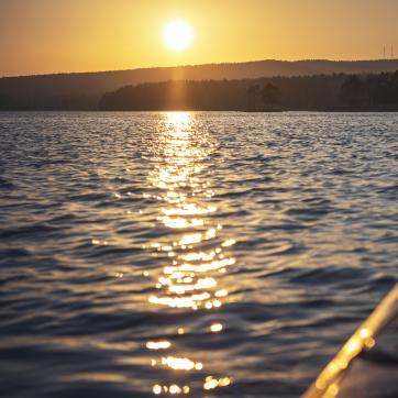 Kanot i vatten med fin solnedgång.