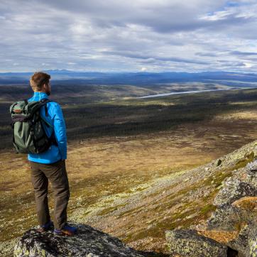 Guy stands on Nipfjället and looks out over the view.