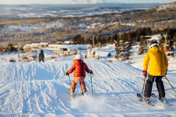 Barn som åker skidor i vårsolen.