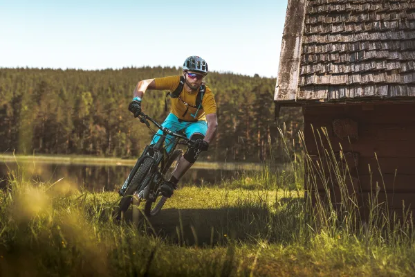 Kille som cyklar på en mountainbike längs en led.