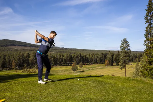 Golfare som svingar golfklubban.