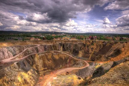 Ett stort dagbrott med en väg som går genom det.