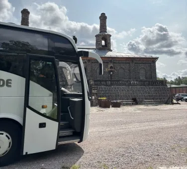 Buss står med dörren  öppen framför entré till Verket.