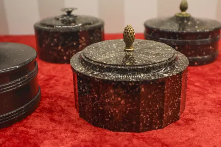 Porfyrföremål uppställda på en röd duk.