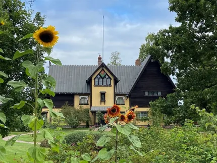 Exteriör av huset där Anders Zorn bodde med en ljusgul fasad med mörkt trä.