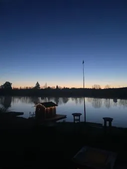 Ett litet hus på en brygga vid en sjö.