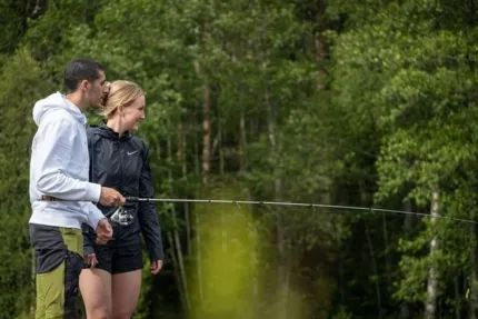 Ett par som står på en brygga och fiskar.