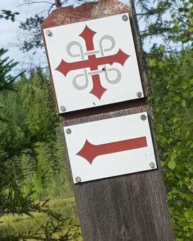 Ledskylt Romboleden samt en röd riktnings pil på en stolpe.