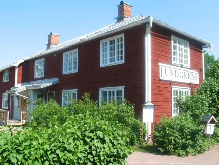 A red wooden building with white windows.