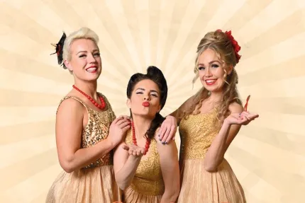 Tre kvinnor i guldglittrande klänningar.