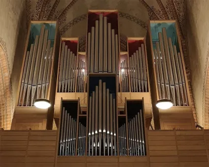 Piporna på en kyrkorgel, en bit av taket i en kyrka.