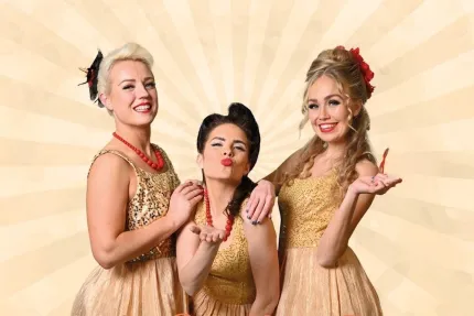 Tre kvinnor i guldglittrande klänningar.