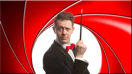 En person i smoking som håller en pinne.