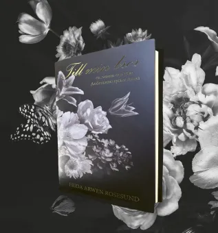 En uppslagen bok med mörkt omslag och blommotiv, guldtext och en fjäril mot svartvit blomsterbakgrund..