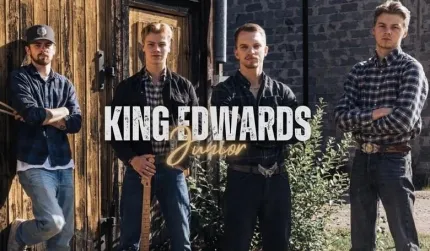 Fyra män i jeans och rutiga skjortor står utanför en trä- och stenbyggnad, med texten “KING EDWARDS”..