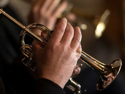 En hand som håller i en trumpet.