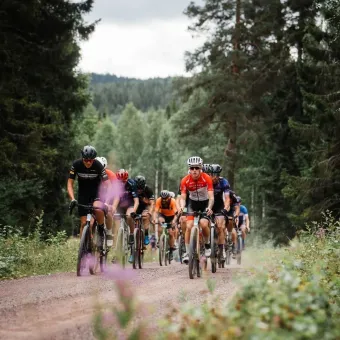 Cyklister i cykelkläder på en grusväg.