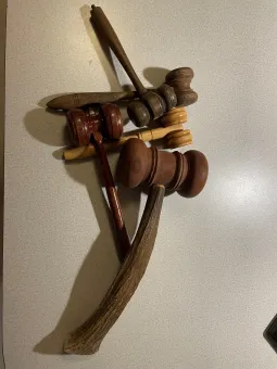 Flera klubbor och träredskap i olika färger ligger korsade på en ljus, mönstrad bänkskiva inomhus..