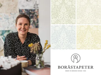 Person vid bord med tapetprov och kaffekopp; till höger syns fyra blommönstrade tapeter och en logotyp..