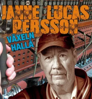 En man med  skäggstubb keps, Janne Lucas Persson med orange bokstäver, växeln hallå med blå bokstäver.
