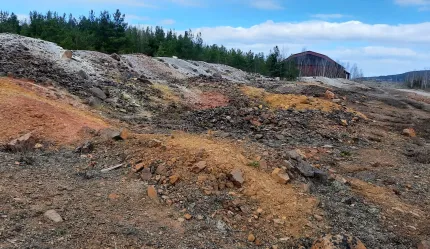 En kulle, miljön är karg och marken till viss del täckt av slaggsten.