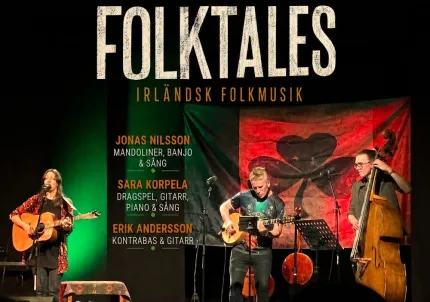 Affischbild med tre musiker på scen som spelar gitarr och kontrabas, med stor text “FOLKTALES” ovanför..