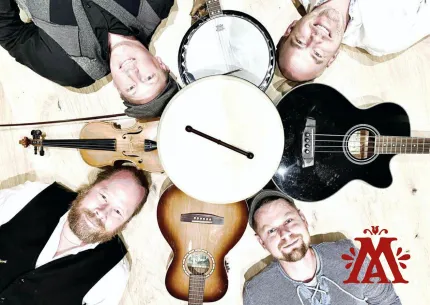 Fyra män ligger på ett trägolv runt en stor trumma, med fiol, banjo och två gitarrer bredvid..