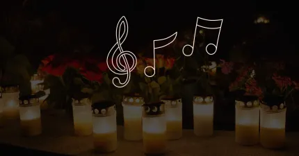 Tända gravljus i glas står framför blommor i mörker, med vit treble-klav och noter överlagrade..